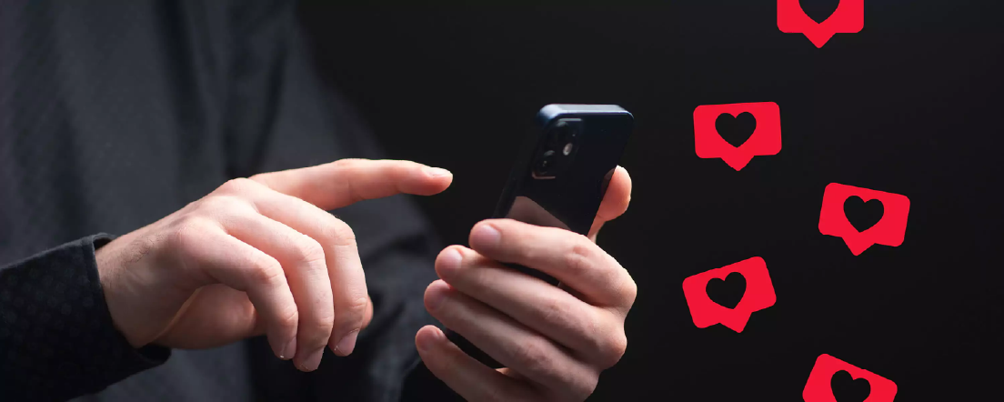 Des mains tenant un téléphone avec des émojis en cœur flottant autour