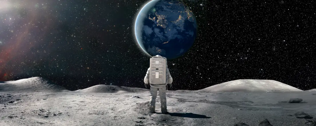 Astronaut standing on the Moon looking towards Earth